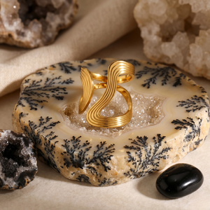 18k gold circlet ring with a wavy style on agate stone background with geodes and black stone accents