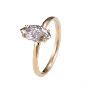 A gold ring with a marquise-cut clear gemstone in a four-prong setting, shown on a plain white background - J.Collins Jewelry