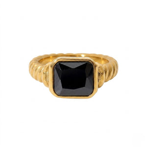 Gold signet ring with a large black gemstone in a square setting, featuring a textured band design.