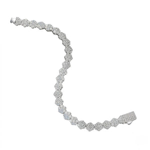 Sterling silver tennis bracelet with linked floral cluster cubic Moissanite stations and an iced-out box clasp unclasped in an S-curve layout on a plain white background by J.Collins