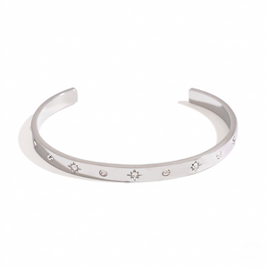 Silver cuff bracelet with starburst engravings and small gemstones