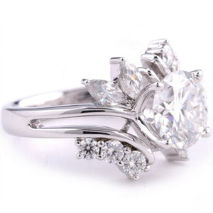 Sterling silver ring featuring a round center cubic Moissanite stone flanked by marquise accents shown close-up on a plain white background by J.Collins