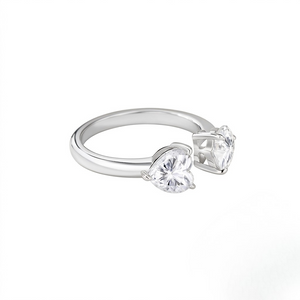 Sterling silver open adjustable cuff ring featuring dual heart-shaped prong-set cubic Moissanite gemstones shown at an angle on a plain white background by J.Collins