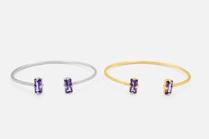 Two bangle bracelets, one silver and one gold, each with a purple gemstone on a white background - Duara Cuff Bracelet - JCollins Jewelry