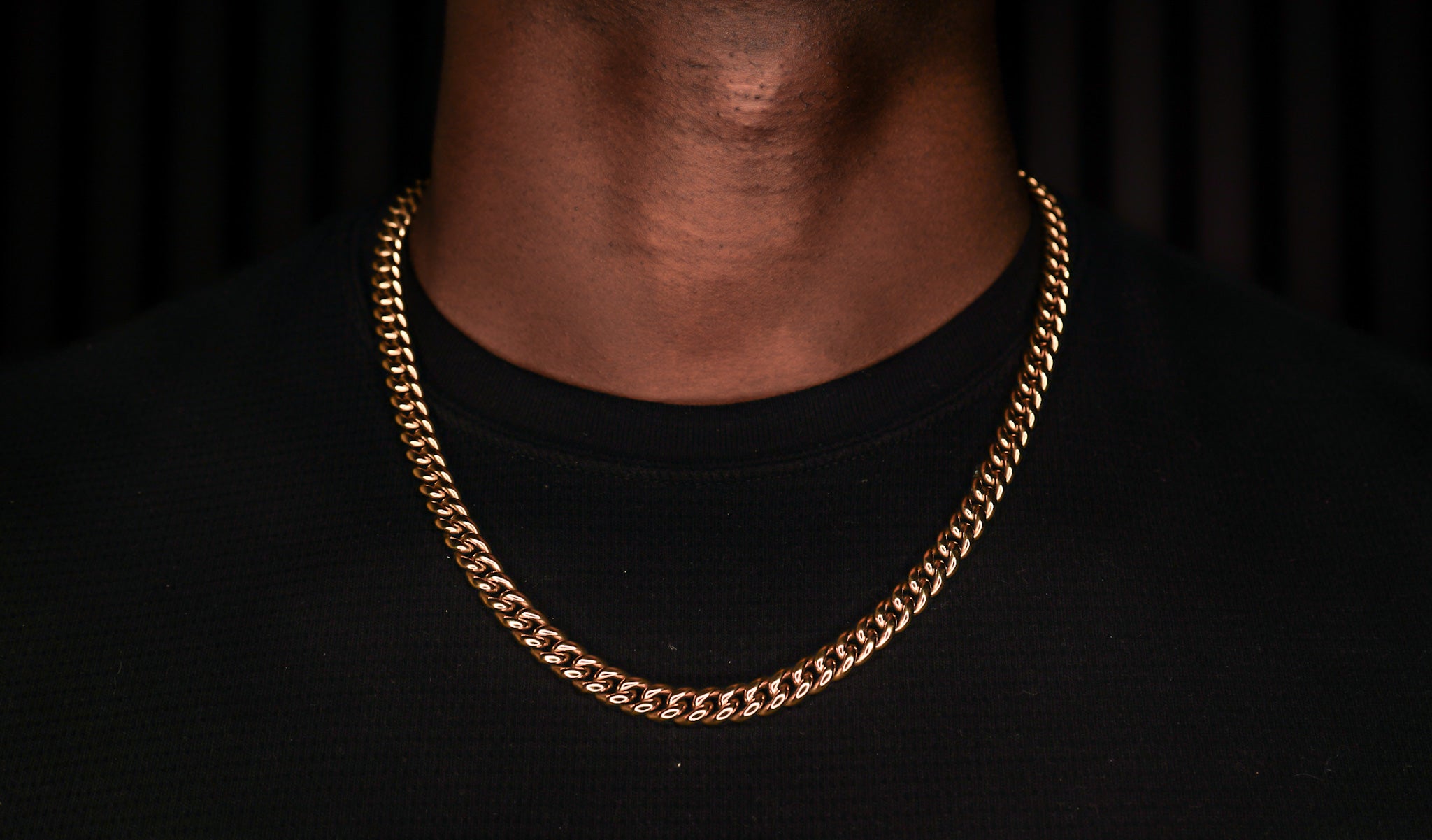 Gold chain necklace on a black background -Iconic-Cuban-Chain-JCollins-Jewelry