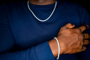 Person wearing a blue shirt with a silver chain necklace and bracelet-Tennis-Silver-Bracelet-JCollins-Jewelry