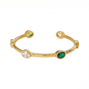 Gold bracelet with green and clear gemstones on a white background - Lush Inset Cuff - J. Collins Jewelry