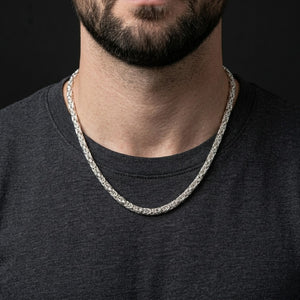 Man wearing a silver mesh rope necklace against a dark shirt background