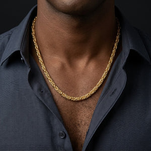 Gold mesh rope necklace worn with an open dark shirt on a model.
