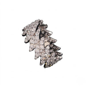 A white gold ring featuring a layered, wavy design paved with clear cubic zirconia stones, set against a plain white background - J.Collins