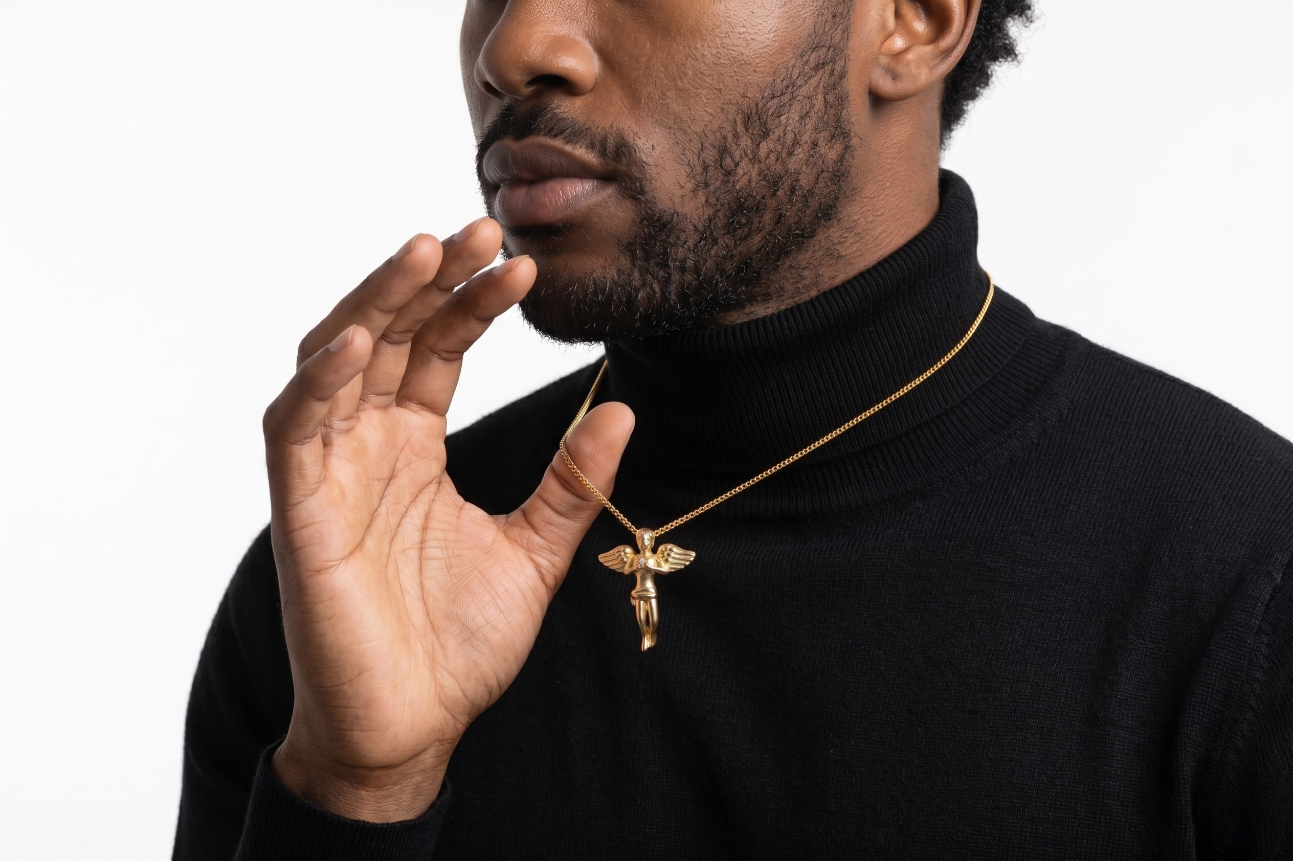 Man wearing a black turtleneck and gold necklace with a pendant on a white background-J.Collins Jwelry