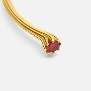 Gold bangle with a red gemstone on a light gray background - Valora Cuff - JCollins Jewelry