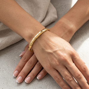 Gold Galaxy Crystal Bracelet on wrist with relaxed hands on a marble surface