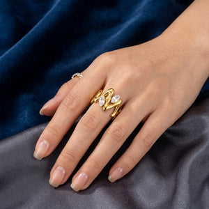 Gold Marquise Vine Ring with elegant design shown on a hand against blue and gray fabric background