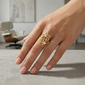 Gold floral ring with diamonds on a hand, modern interior background