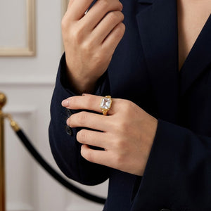Gold Premier Bezel Ring with large gemstone on model's hand in formal setting