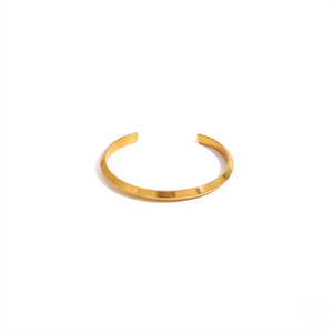 Gold torque cuff bracelet on a white background displaying a sleek, minimalist design