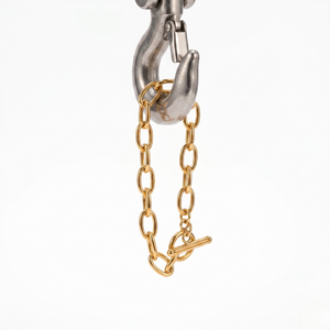 Gold-plated chain bangle with toggle clasp, hanging on a metallic hook