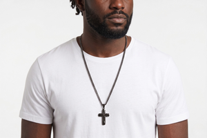 Man in white shirt wearing silver cross necklace with dark chain