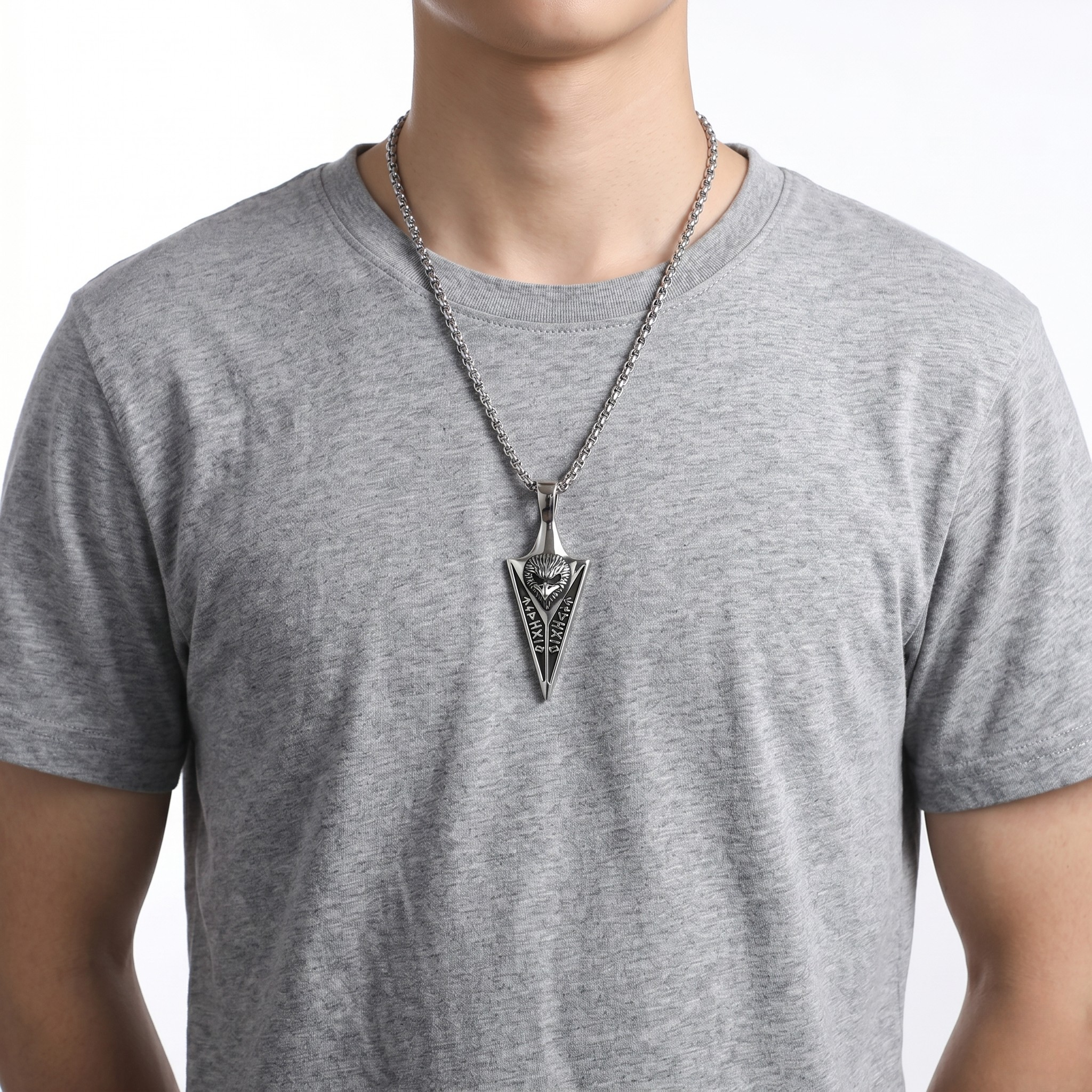 Nordic totem pendant in silver worn on a chain by a person in a gray T-shirt
