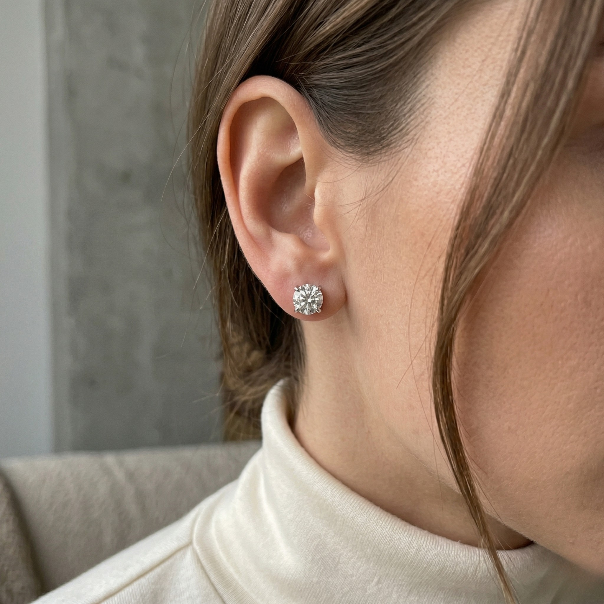 Woman Wearing Silver Diamond Stud Earrings with White Turtleneck - 10K_Gold_Lab_Diamond_Earrings_Basket_0.418ct - J. Collins Jewelry 