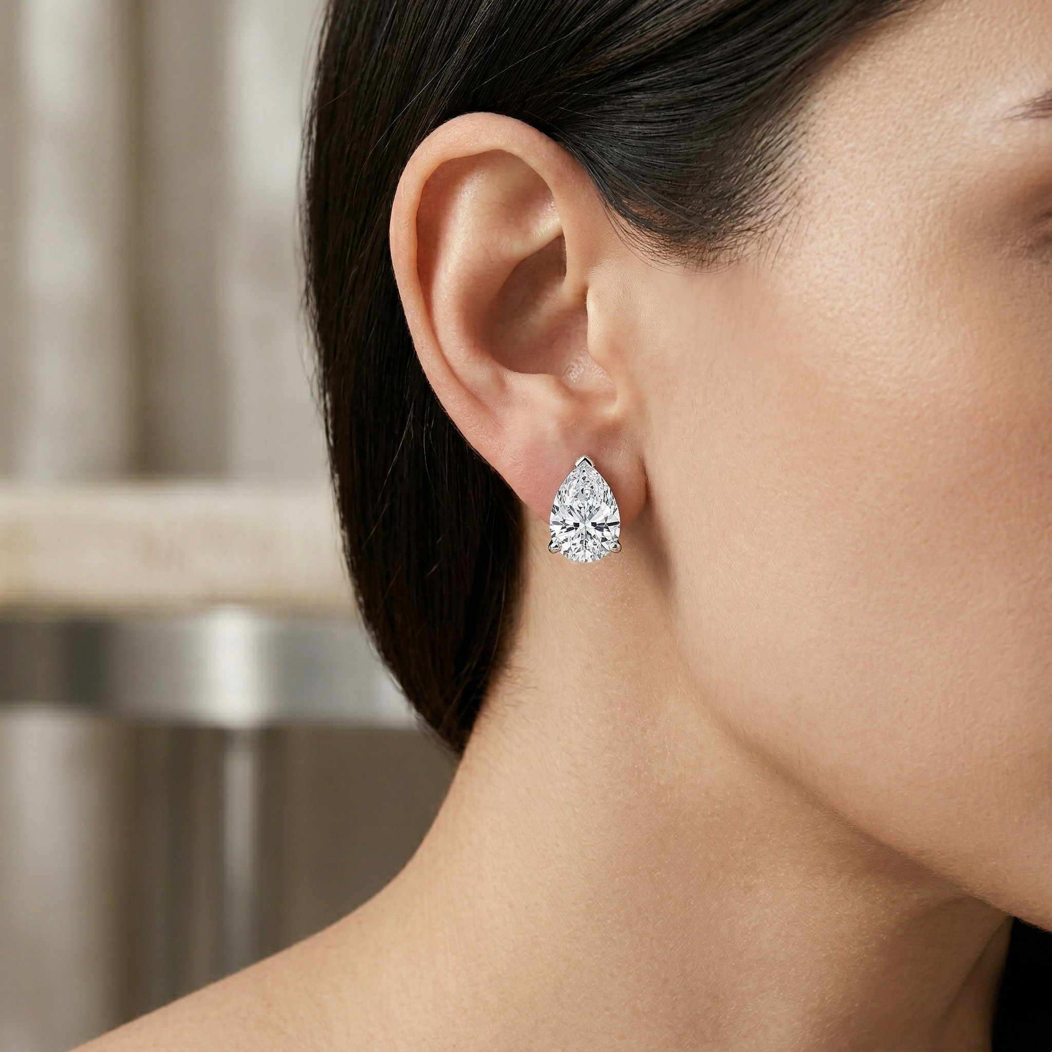 Teardrop-shaped diamond earring worn by a model with a neutral background - 10K White Silver Lab Diamond Earrings 0.549ct by J.Collins Jewelry 