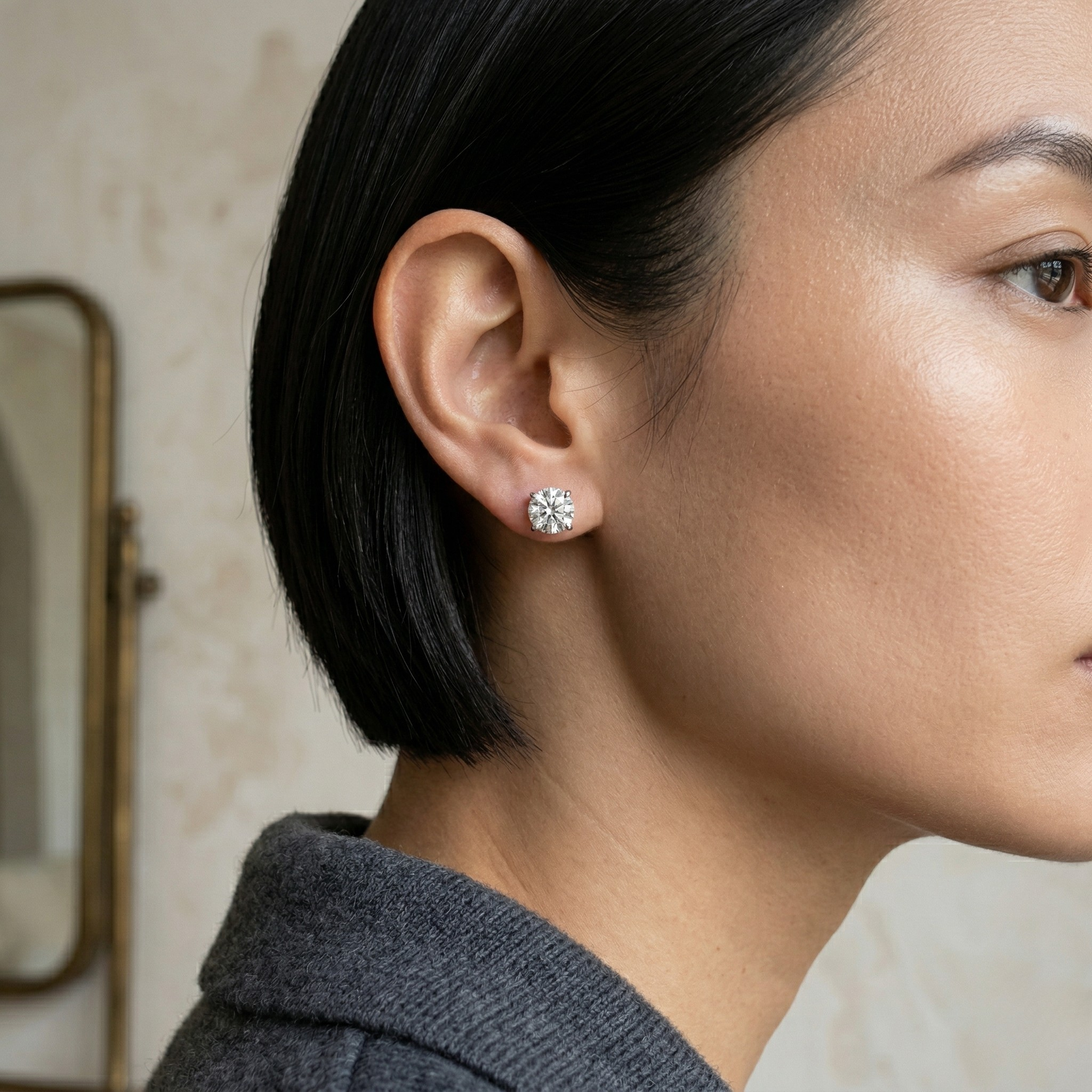 Close-up of a person wearing silver diamond stud earrings with a neutral background - 10K_White_Silver_Lab_Diamond_Earrings_0.529ct - J. Collins Jewelry 