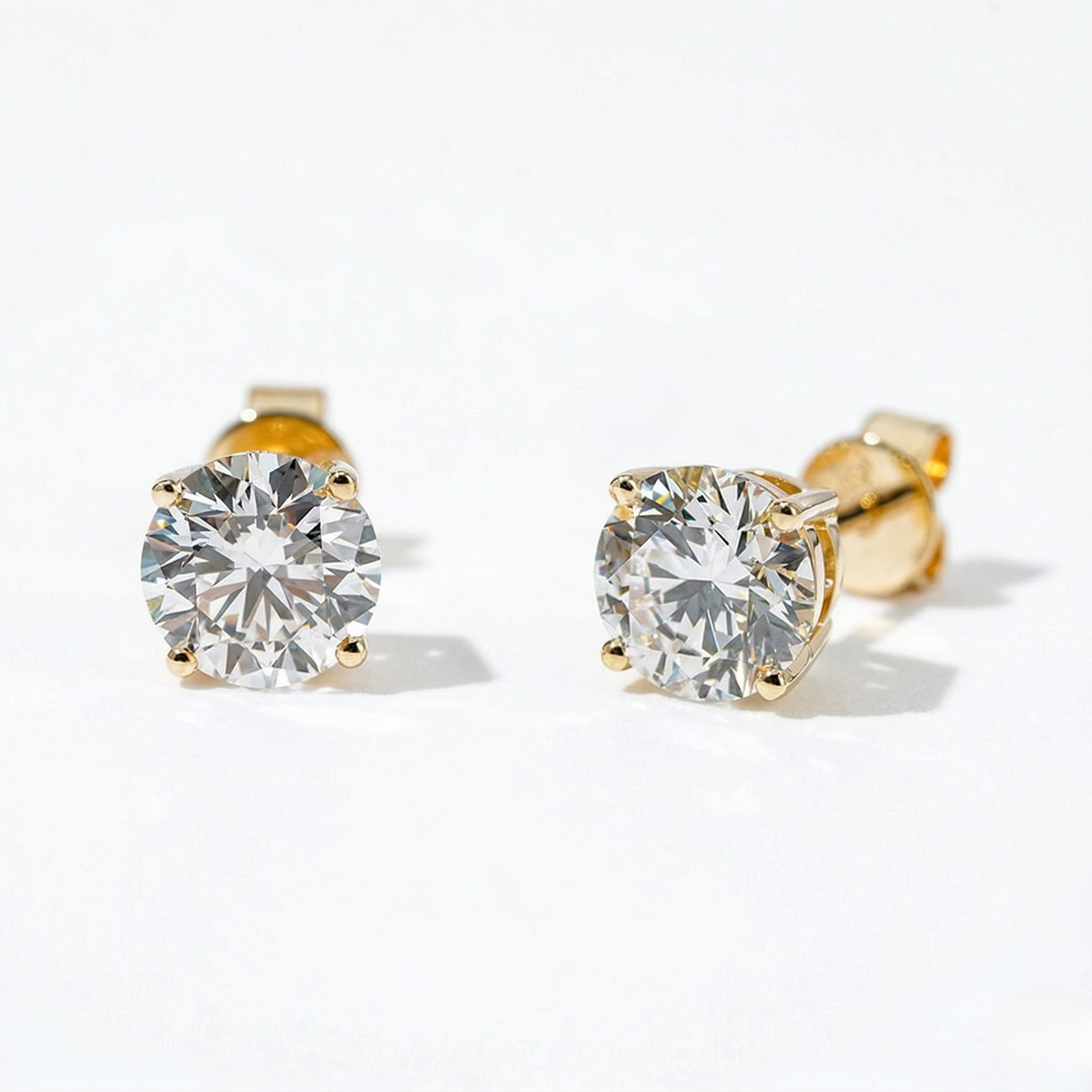 Gold stud earrings with clear gemstones on a white background - 10K Yellow Gold Lab Diamond Earrings Basket 1.1ct - J. Collins Jewelry 