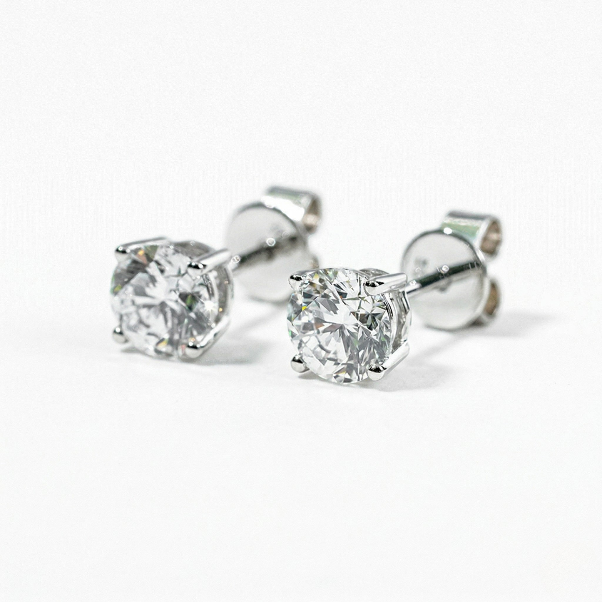 Pair of silver stud earrings with clear gemstones on a white background - White Gold Diamond Earrings - J. Collins Jewelry 