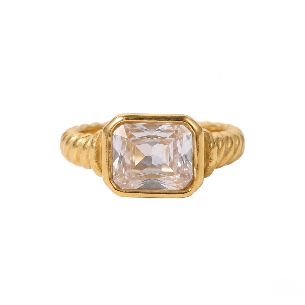 Gold premier bezel ring with a square-cut clear gemstone in a ribbed band design.