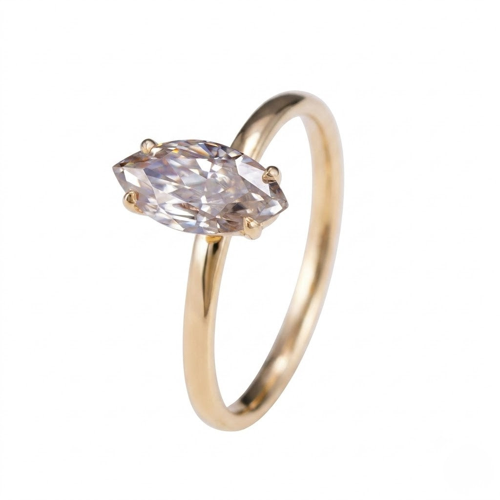 A gold ring with a marquise-cut clear gemstone in a four-prong setting, shown on a plain white background - J.Collins Jewelry