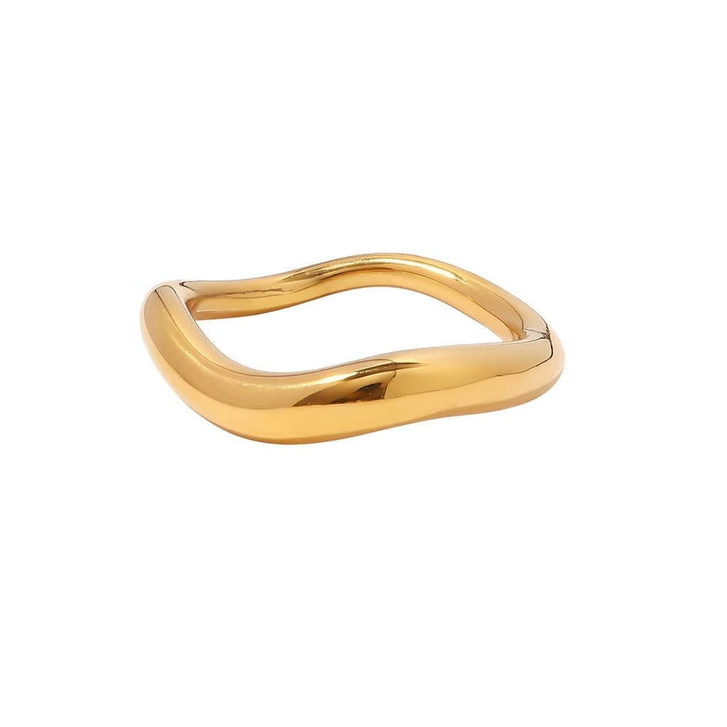 Gold wave-shaped ring with a smooth, flowing design on a white background