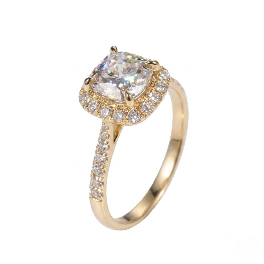 Gold ring featuring a cushion-cut cubic Moissanite center stone surrounded by a halo of round accents shown at an angle on a plain white background by J.Collins
