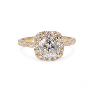 Gold ring featuring a cushion-cut cubic Moissanite center stone surrounded by a halo of round accents shown facing forward on a plain white background by J.Collins
