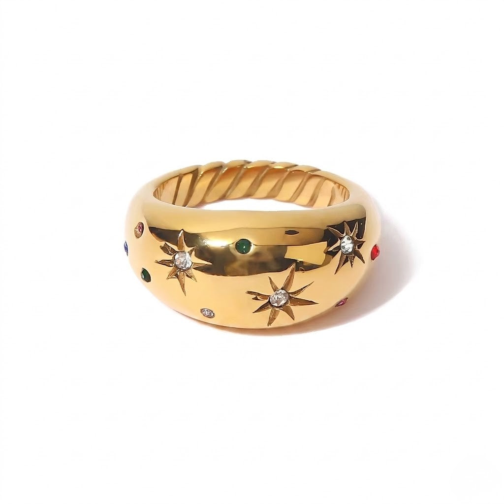 Gold starburst ring with colorful gemstones and diamond accents on a twisted band.