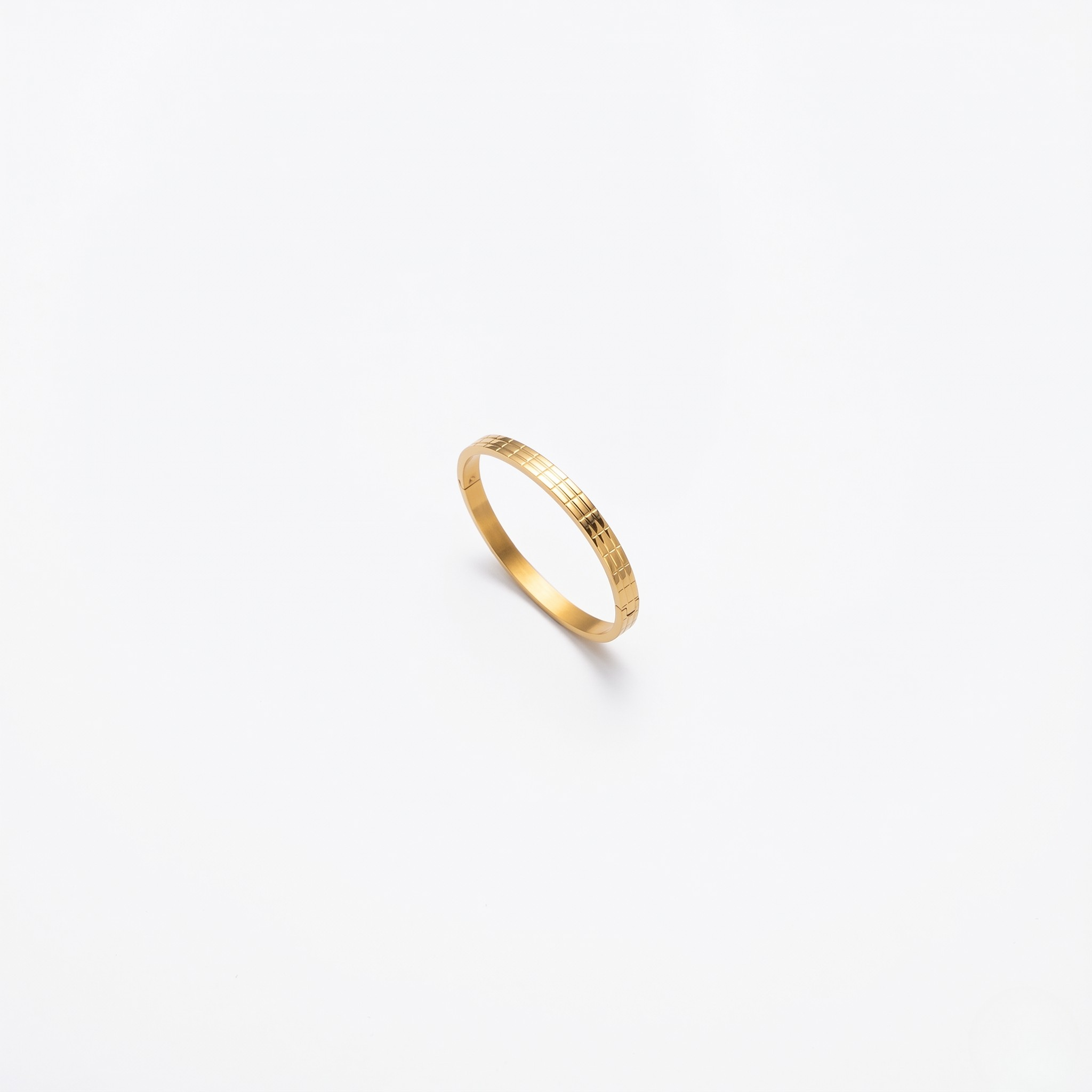 Gilded gold bracelet with a sleek, textured design on a plain white background.