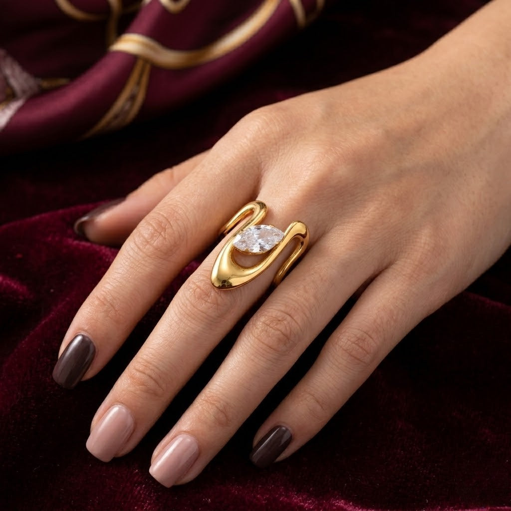 Gold Summit Focal Ring with diamond center on a hand resting on burgundy velvet fabric