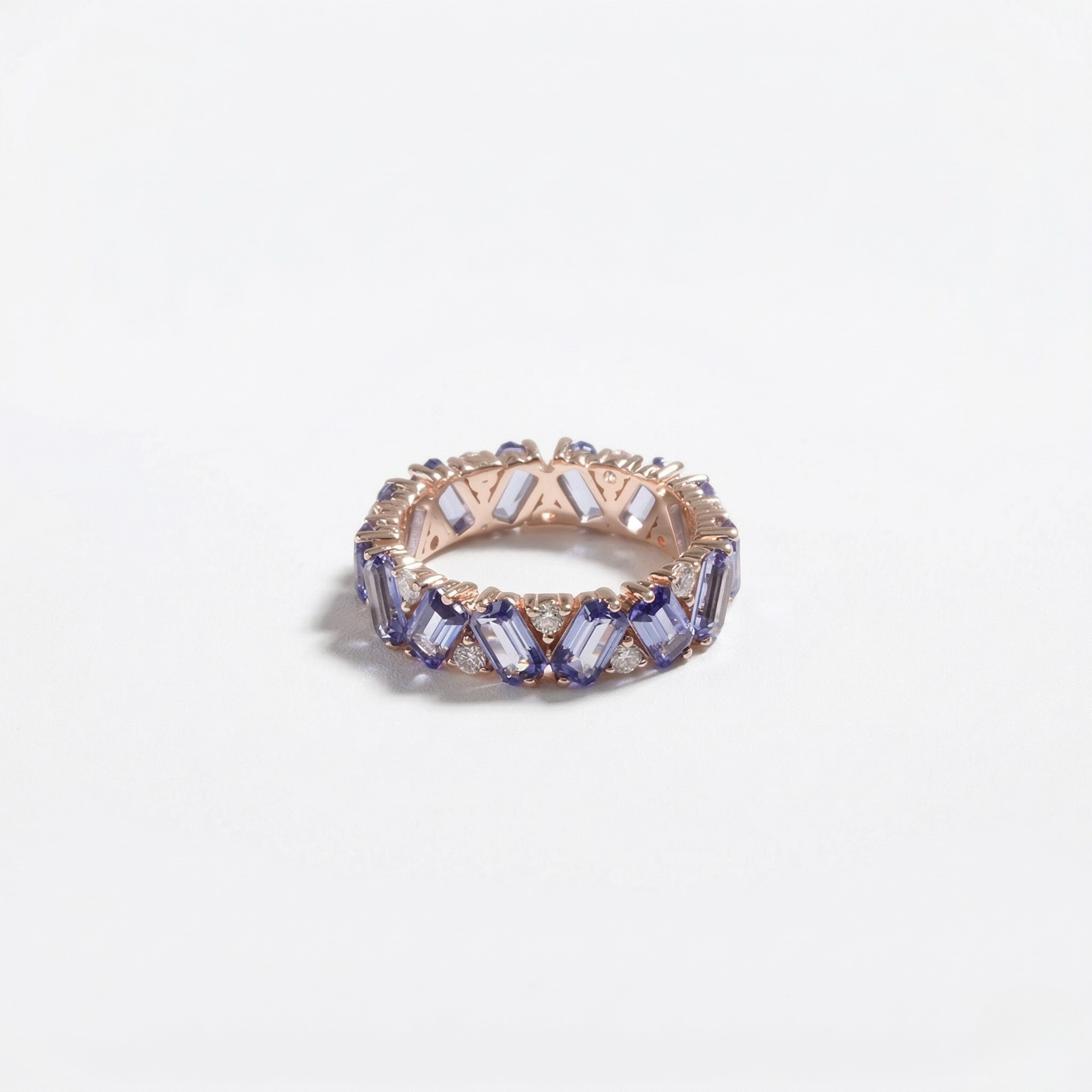 14K rose gold ring with lab-created sapphires in a geometric setting on a plain background