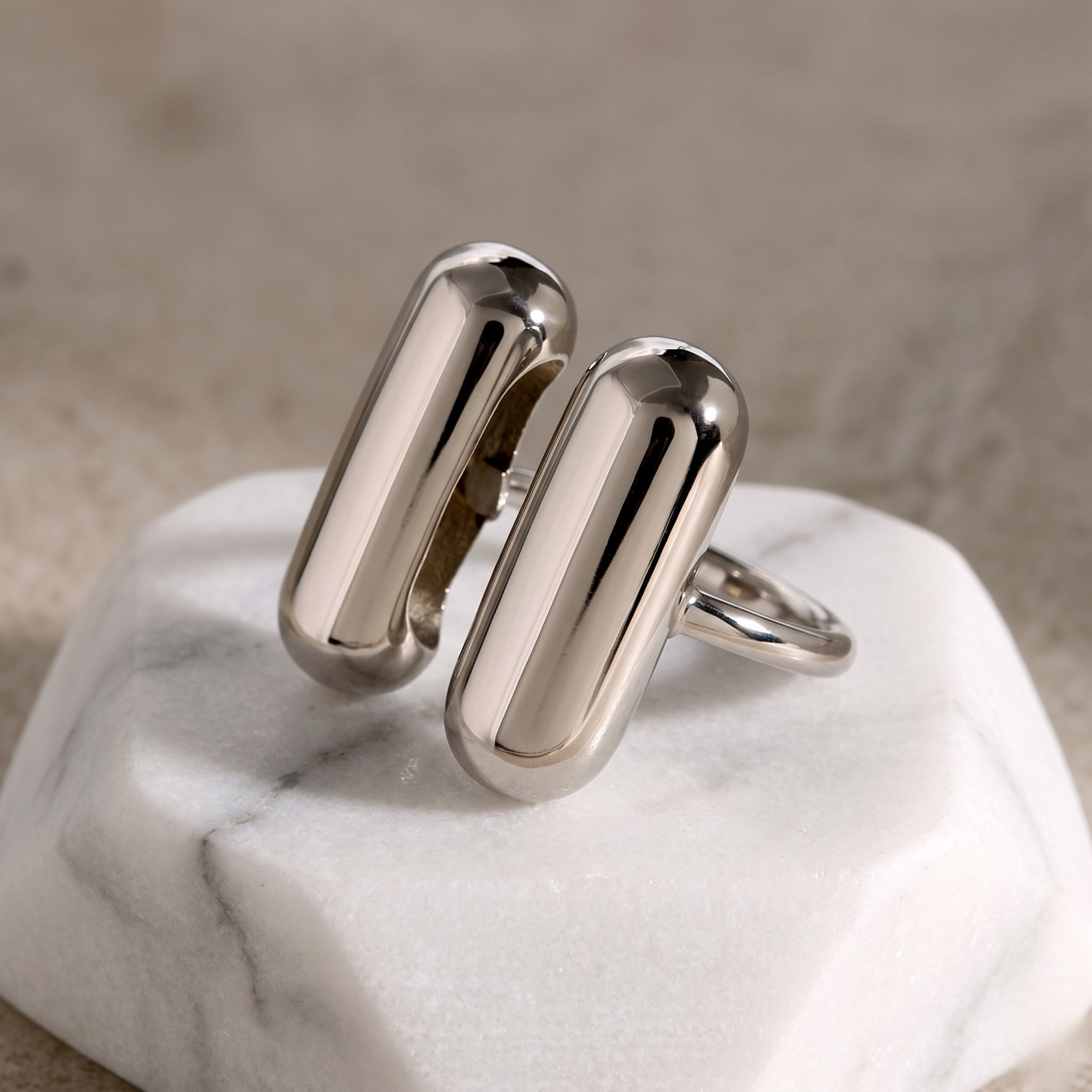 Twin Bar Ring in silver with a modern, polished style displayed on a marble background