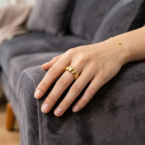 Gold Velvet Heart Ring on hand with gray couch backdrop