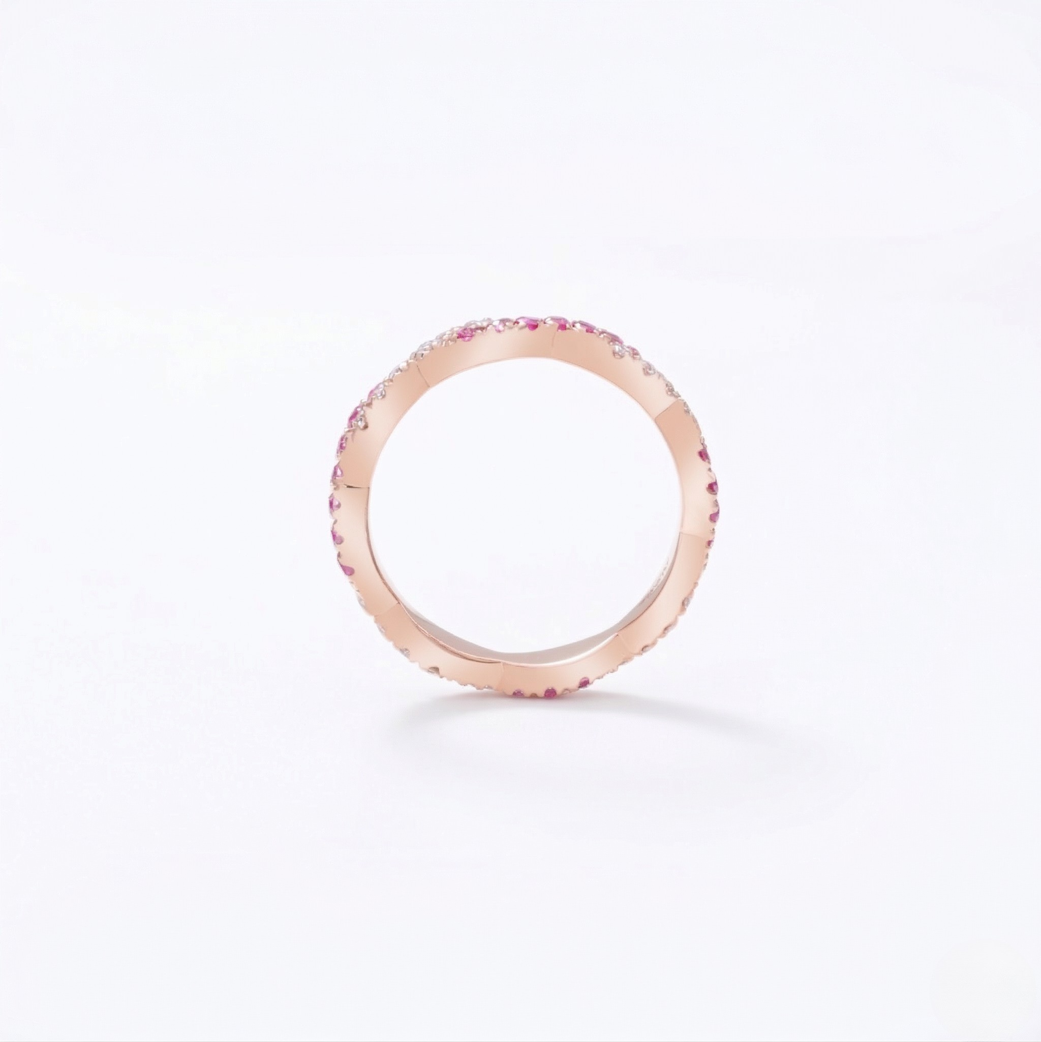 14K rose gold ring with lab-created rubies in a minimalist design on white background