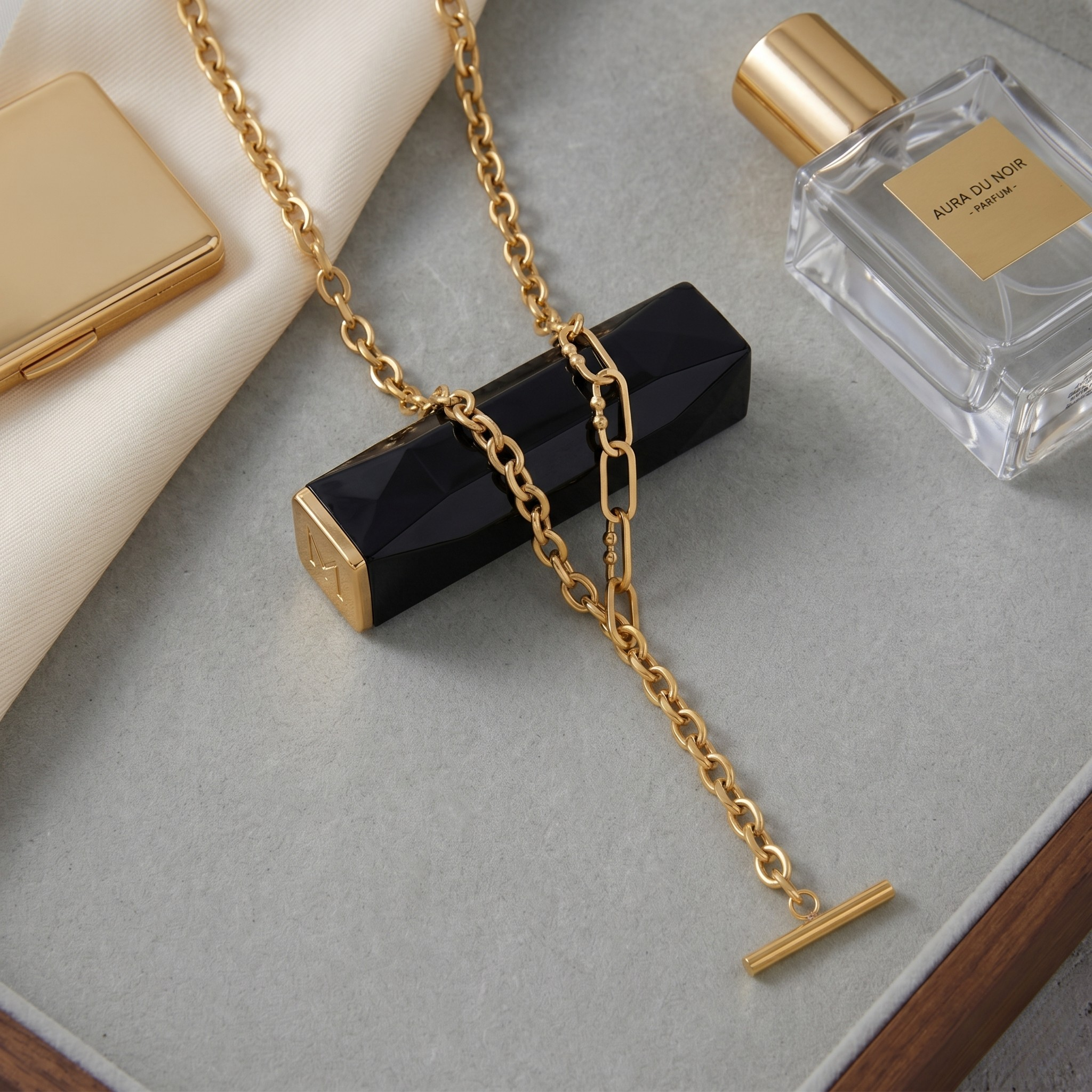18k gold paperclip choker chain on gray surface with perfume and cosmetics nearby