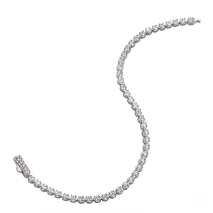 Classic single-row sterling silver tennis bracelet set with round cubic Moissanite crystals unclasped in an S-curve layout on a plain white background by J.Collins
