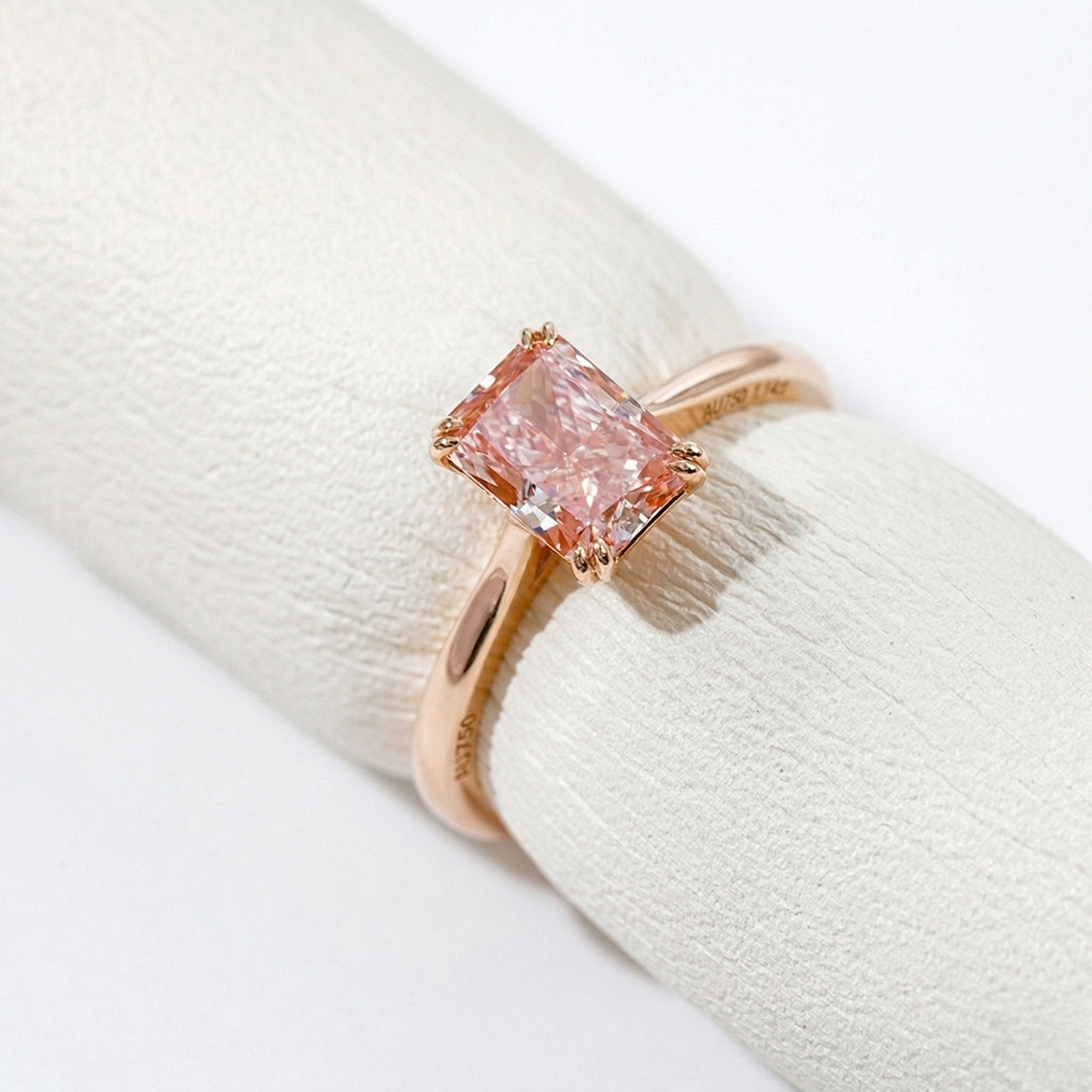 18K rose gold ring with 1.14ct pink lab diamond in a rectangular setting on a light textured surface