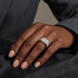 Silver Alpha Crest Ring on hand wearing dark suit jacket