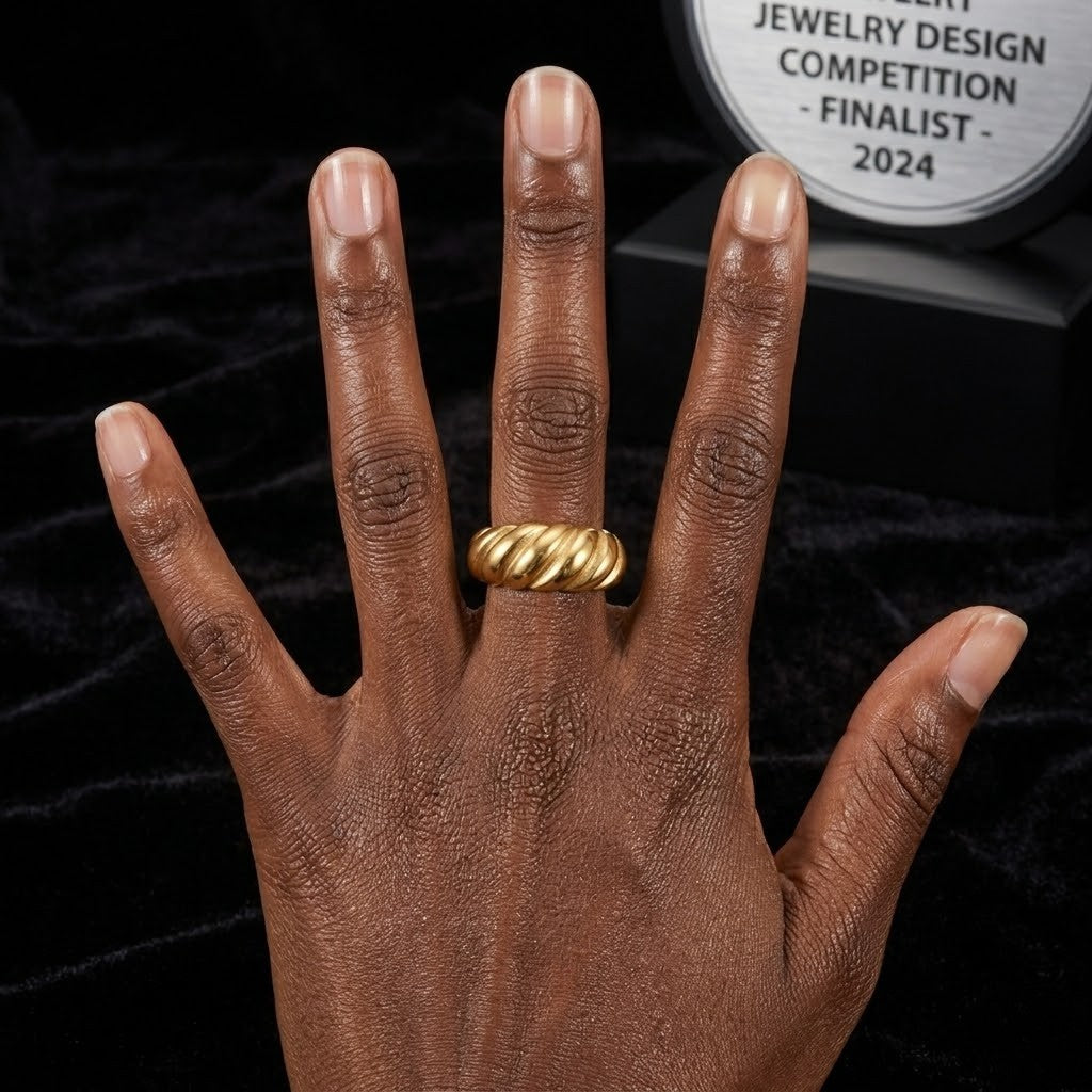 Hand wearing gold fluted ring with black velvet background and jewelry award plaque visible