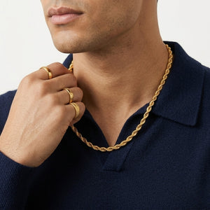 Male model wearing a classic gold rope chain necklace paired with multiple gold statement rings | J.Collins Jewelry