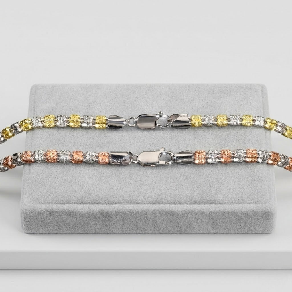 Italian two-tone bead necklaces with silver, gold, and rose gold accents on a gray display stand.