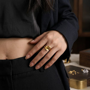 Gold Exotic Pivot Ring on woman's finger, worn with elegant black outfit in lifestyle setting