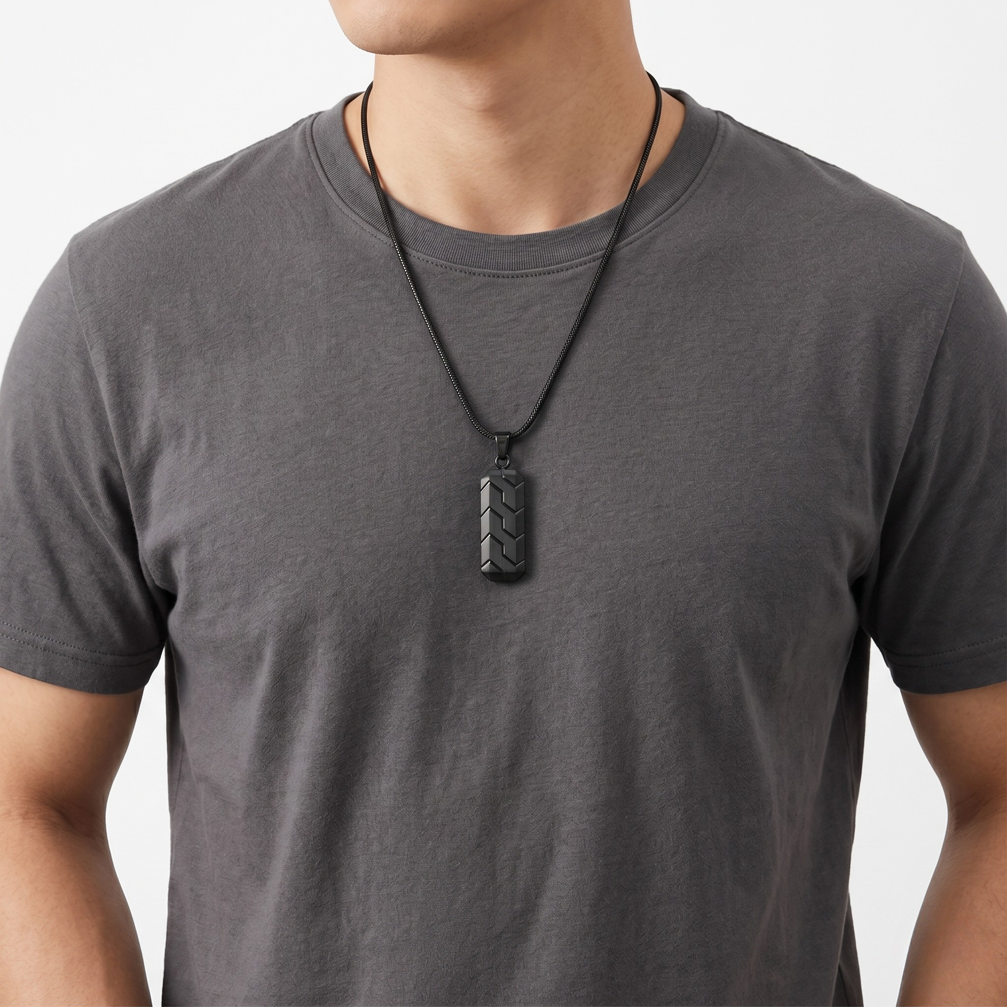 Man wearing a gray t-shirt with a Unique Black Pendant necklace on a leather cord from J.Collins Jewelry.